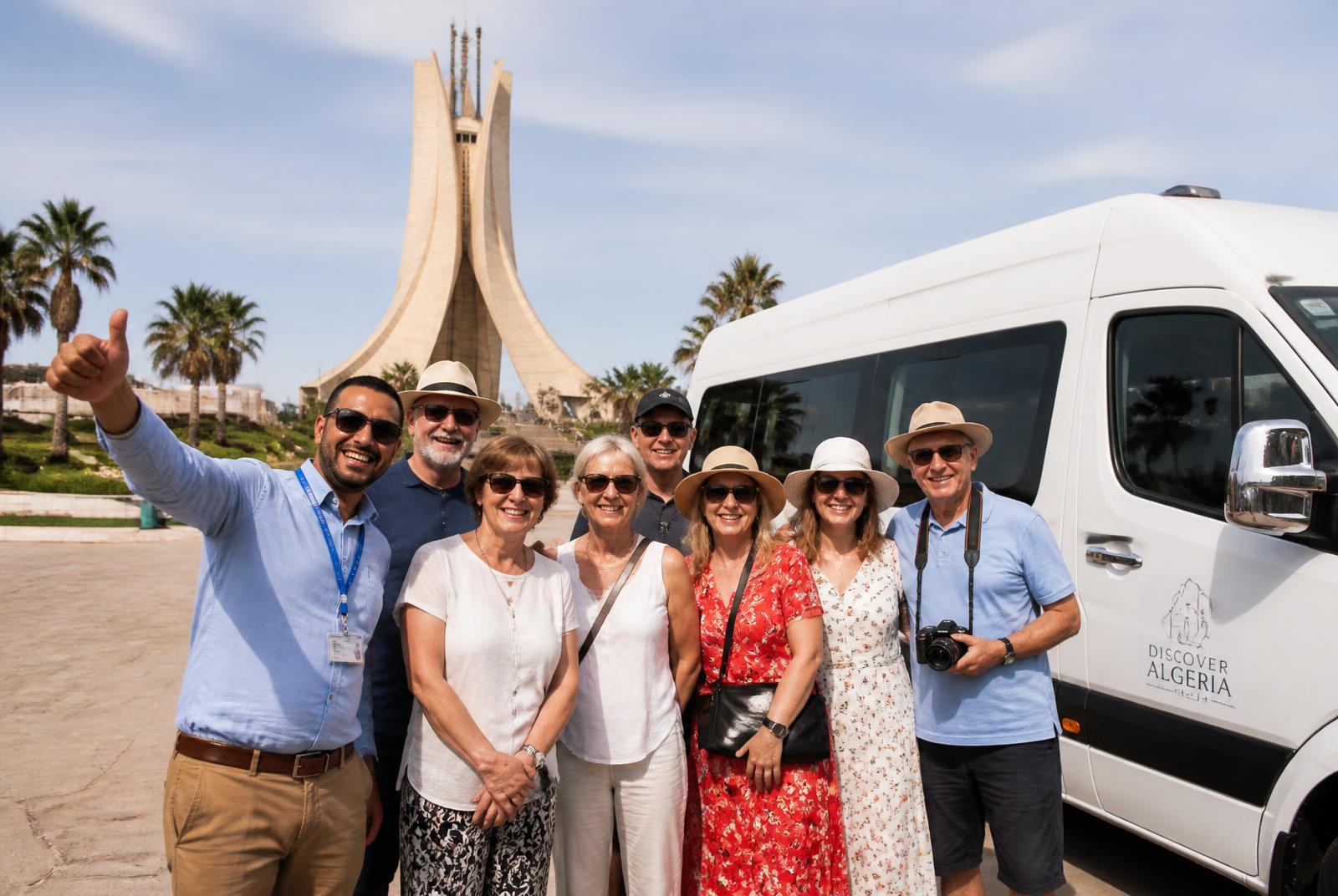 Groupe de voyageurs et guide devant un minibus Panoramic Tours